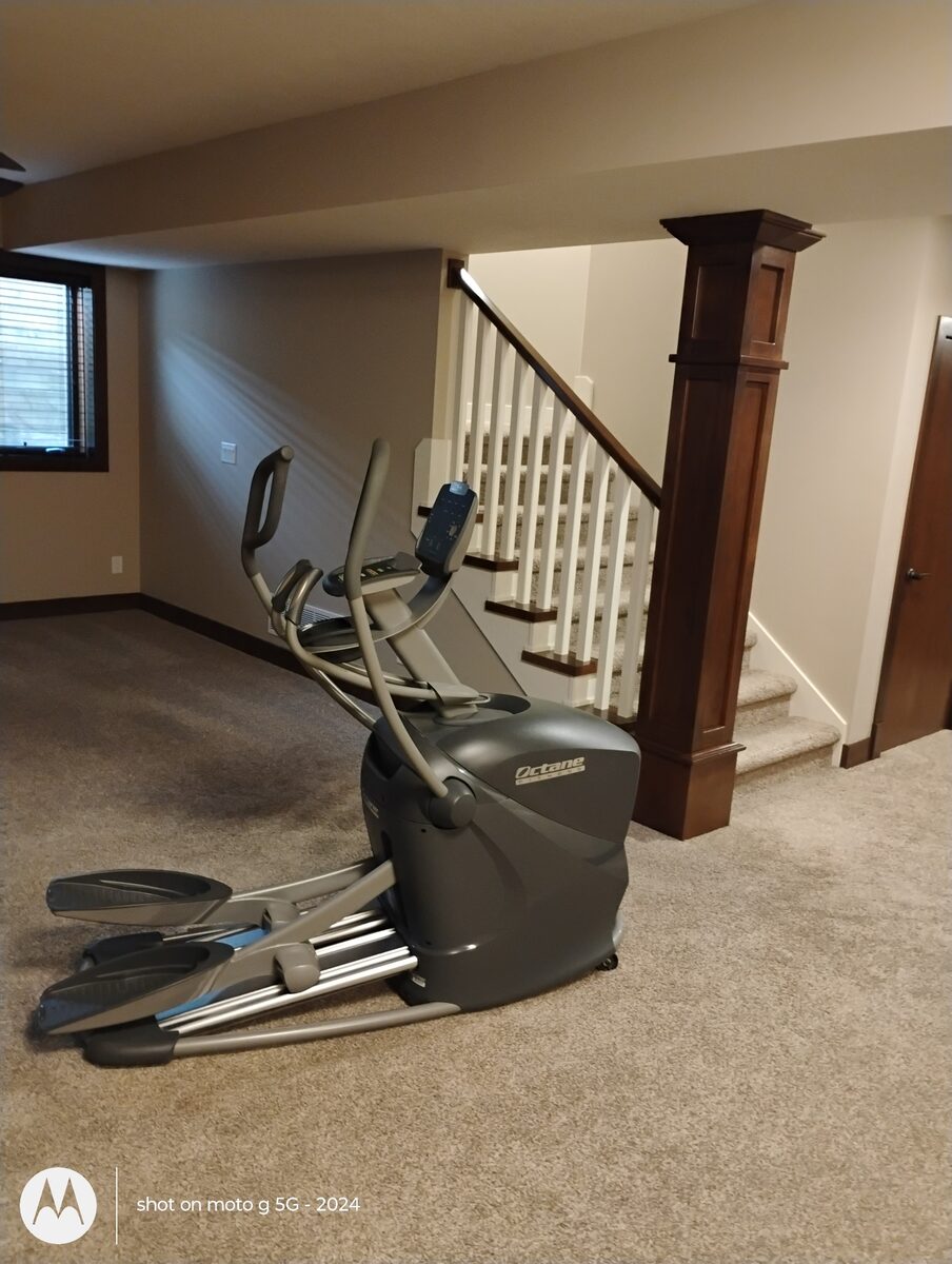 Elliptical exercise machine in a basement before being moved