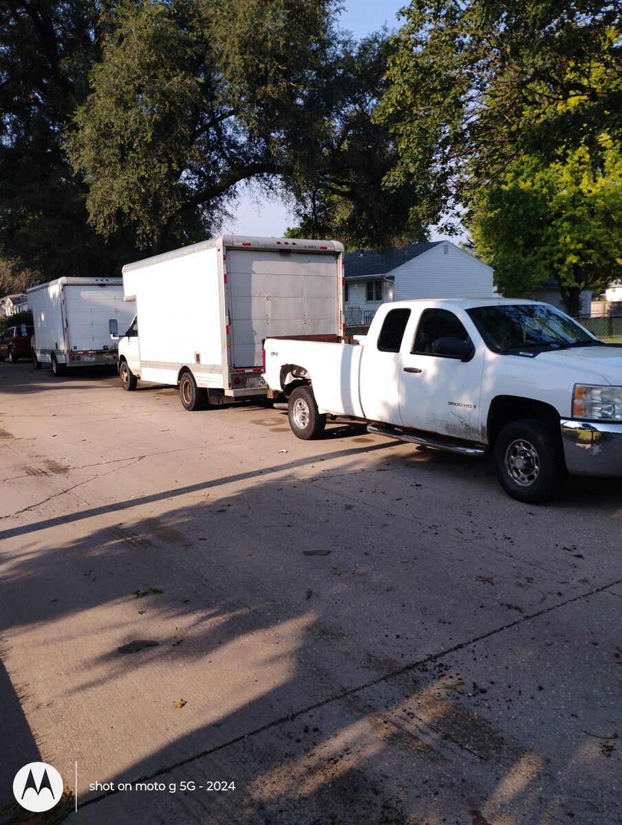 Three white trucks used by We Move You LLC for moves of different sizes
